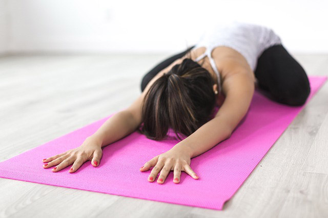 woman stretching on yoga mat